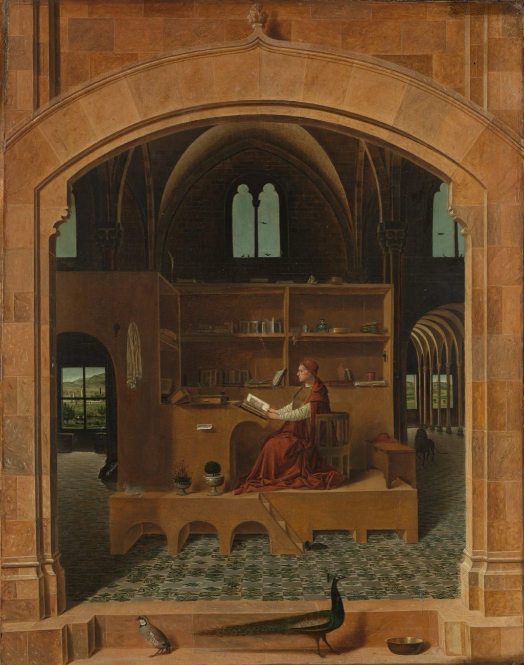 St. Jerome reading at his raised wooden desk inside a vaulted stone study, framed by an arch, with a peacock and a partridge on the step